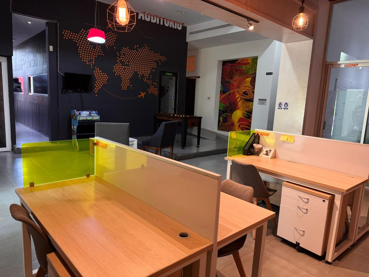 Estaciones de trabajo junto al muro con mapa del mundo y la sala de espera