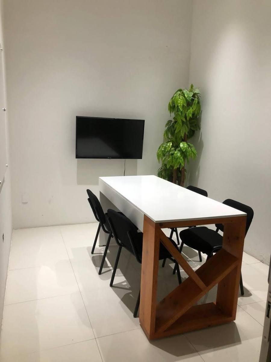 Sala de juntas de D4 con mesa blanca, base de madera y pantalla